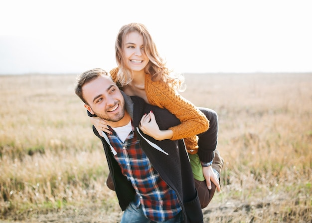 Jeune couple d'homme et femme dans un champ ouvert, ferroutage.