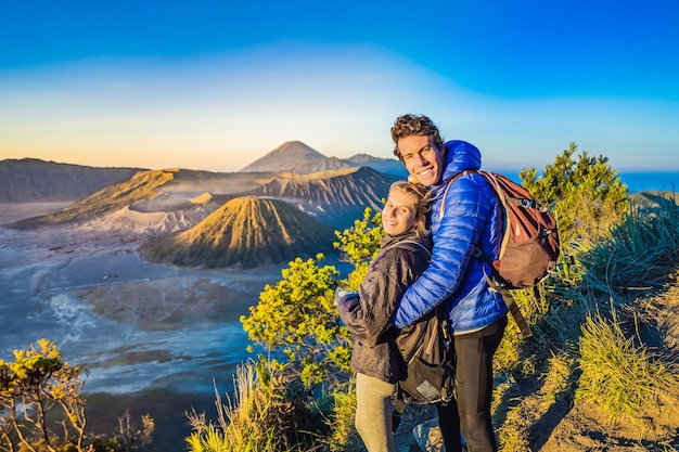 Jeune couple homme et femme rencontrent le lever du soleil au parc national de bromo tengger semeru sur la java