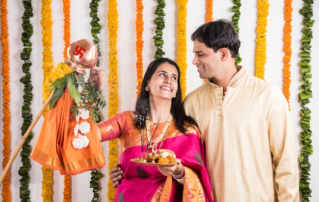 Jeune couple indien intelligent effectuant Gudi Padwa Puja en vêtements traditionnels et pooja thali. C'est un nouvel an hindou célébré dans toute l'Inde