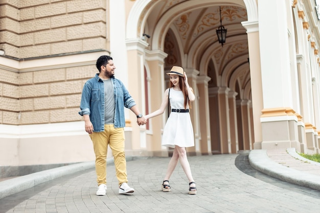 Un jeune couple international amoureux se promène dans une ville européenne.