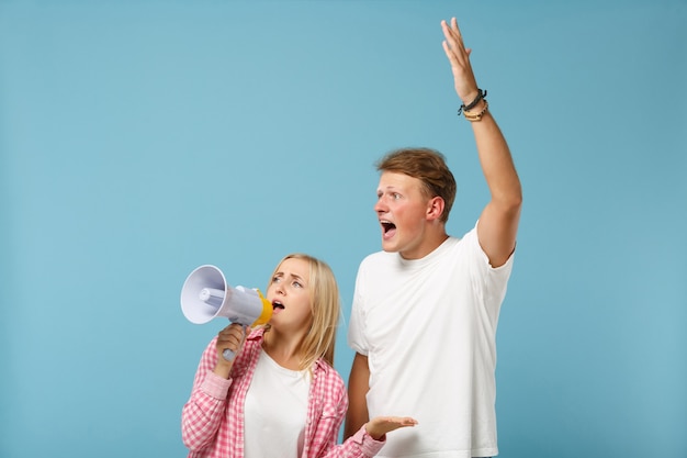 Jeune couple irrité deux amis mec et femme en t-shirts roses blancs posant