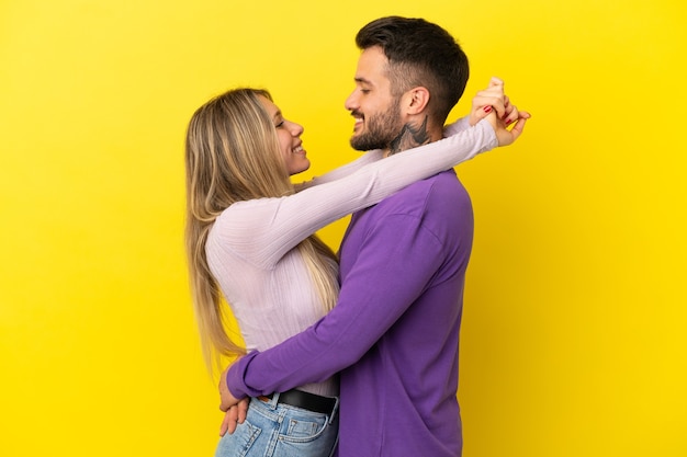 jeune couple, sur, isolé, fond jaune, étreindre