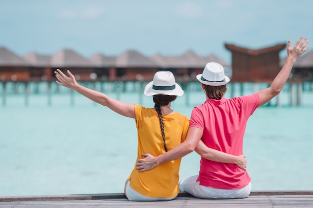 Jeune couple, sur, jetée plage, à, île tropicale, dans, lune de miel