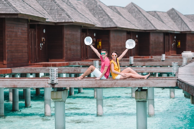 Jeune couple, sur, jetée plage, à, île tropicale, dans, lune de miel