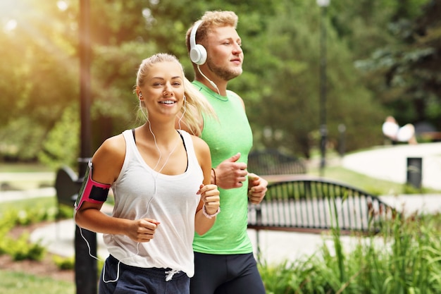 jeune couple, jogging, dans parc, en été