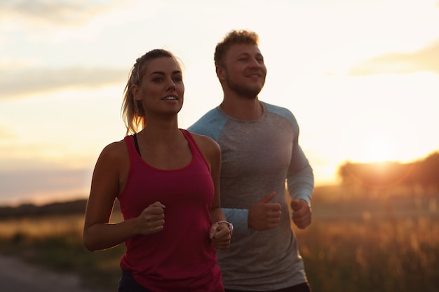 jeune couple, jogging, dans, suberbs, après, coucher soleil