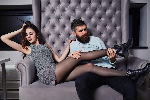 Jeune couple de jolie femme en robe grise et bel homme avec une longue barbe en chemise.