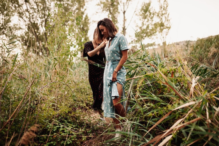 Photo un jeune couple de lesbiennes se promènent dans la forêt.