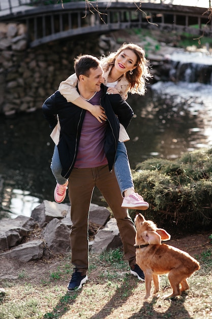 Jeune couple avec leur chien husky se reposant dans la campagne d'automne