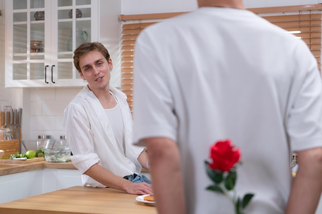 Un jeune couple LGBT célèbre la journée de l'amour avec un verre de vin dans leur cuisine.