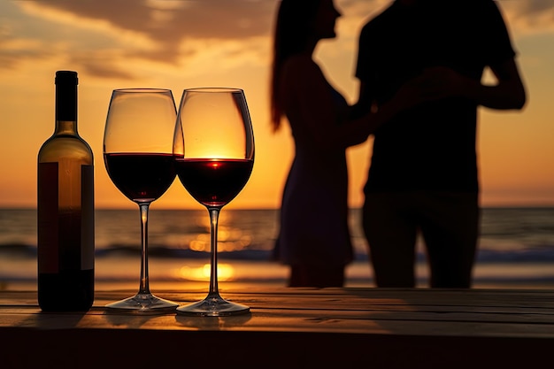 Jeune couple lors d'un rendez-vous sur la plage au coucher du soleil Verres de vin au premier plan Concept de relations