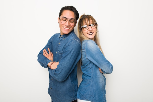 Jeune couple avec des lunettes, regardant par-dessus l&#39;épaule avec un sourire