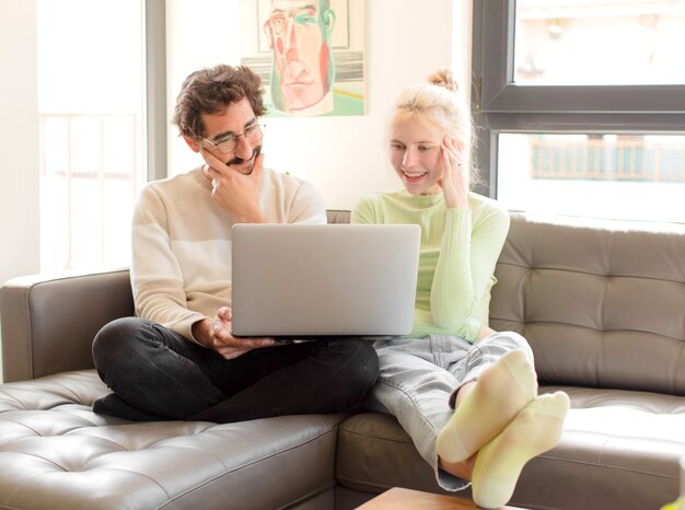 Jeune couple à la maison à l'aide d'un ordinateur portable