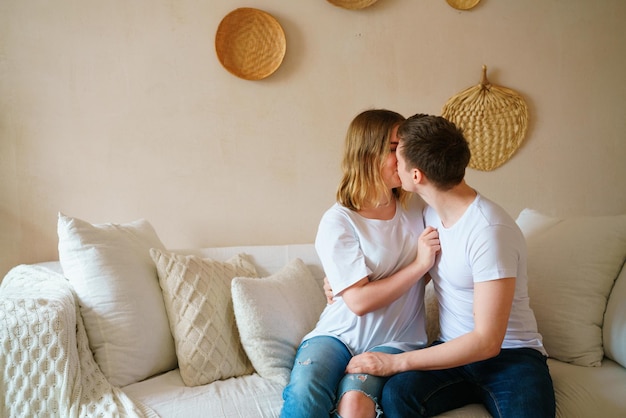 Jeune couple à la maison en vêtements décontractés mec et fille s'embrassent et s'amusent aiment passer du temps ensemble...