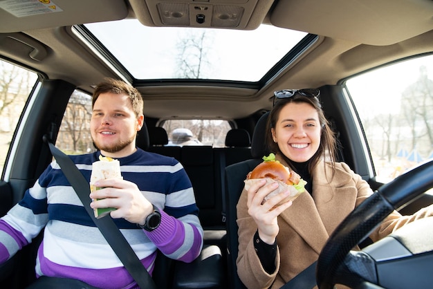 jeune couple, manger, restauration rapide, dans voiture