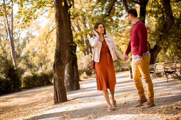 Photo jeune couple marchant dans le parc en automne