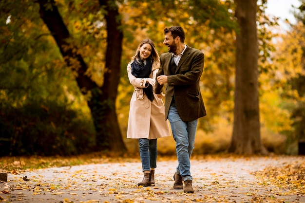 Jeune couple marchant dans le parc en automne