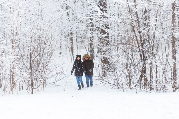 Jeune couple marchant dans un parc enneigé. L'hiver.