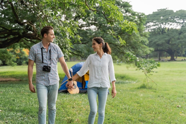 Jeune couple marchant dans le parc avec le sentiment romantique. Amour et tendresse, homme romantique souriant à sa petite amie, concept lifestyle