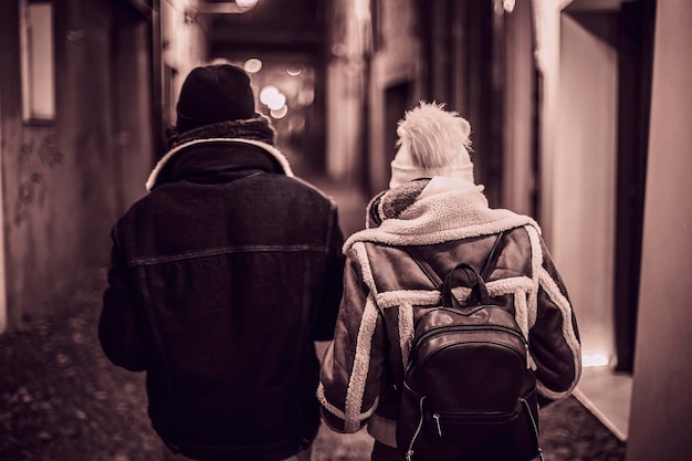 Jeune couple marchant dans une ruelle nocturne