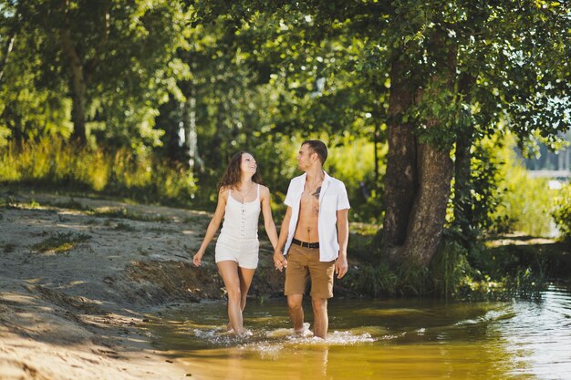 Un jeune couple marchant le long du bord de l'eau 6296