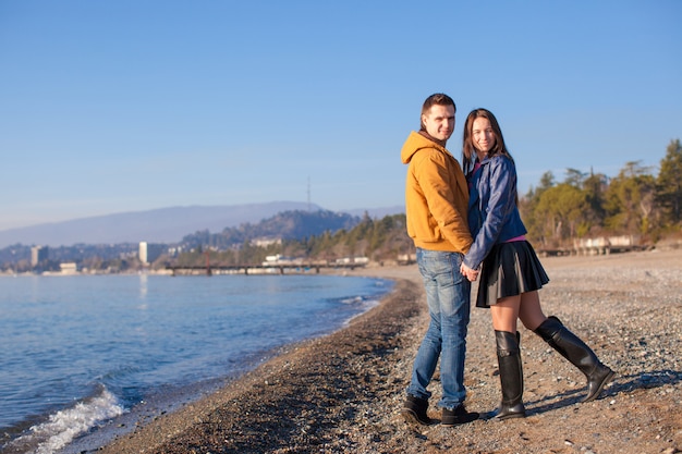 Jeune couple marchant sur la plage un jour d'hiver ensoleillé