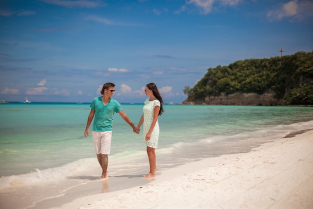 Jeune couple marchant sur la plage de sable près de la mer