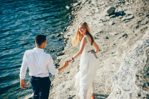 Jeune couple marchant sur la plage de sable