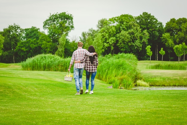 Le jeune couple marchant près du lac