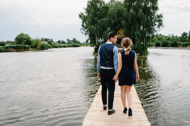 Jeune couple, marche bas, sur, a, pont bois, sur, les, fond, eau