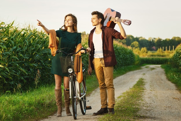 Jeune couple marche par une route de campagne