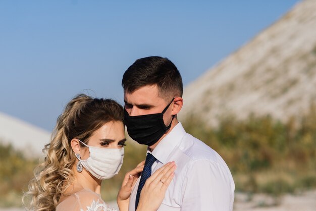 Jeune couple de mariage aimant avec des masques médicaux