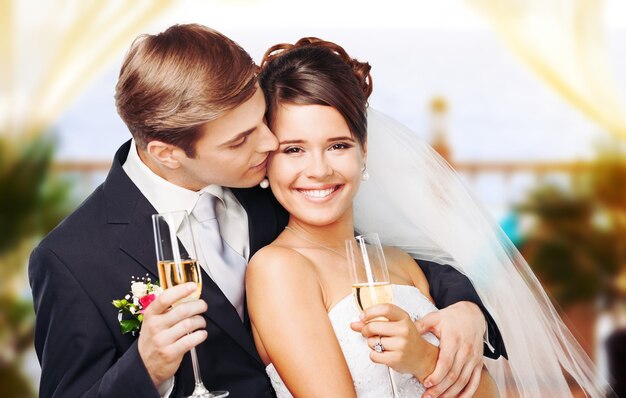 Jeune couple de mariage mariée et le marié tenant des verres de champagne