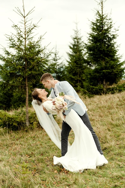 Jeune couple de mariage s'embrassant après la cérémonie de mariage marié s'embrassant sexy couple de mariage de style mariée rustique sur la montagne