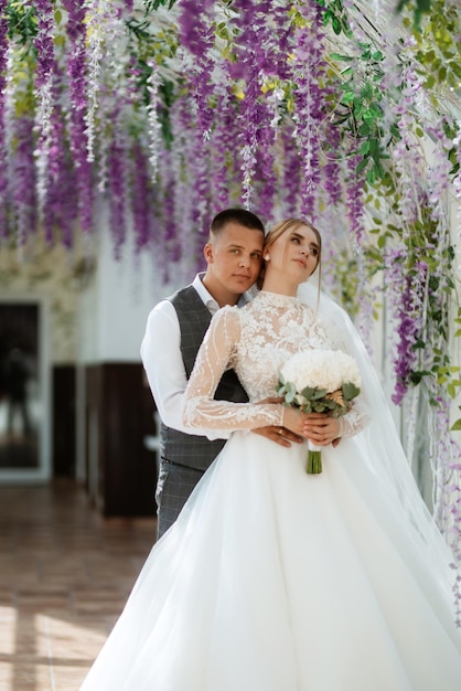 Jeune couple le marié en costume à carreaux et la mariée en robe blanche chic