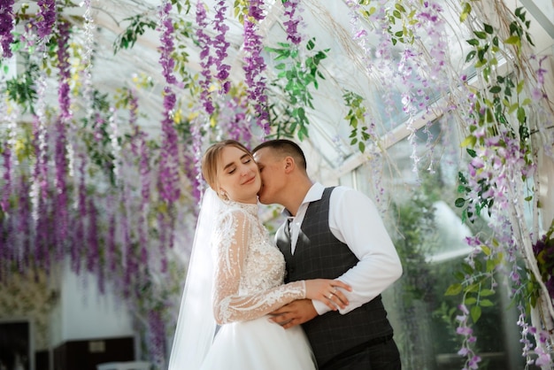 Jeune couple le marié en costume à carreaux et la mariée en robe blanche chic