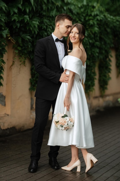 Jeune couple mariée et le marié dans une robe courte blanche