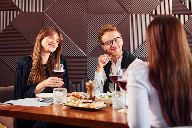 Jeune couple et mère à l'intérieur du nouveau restaurant de luxe moderne