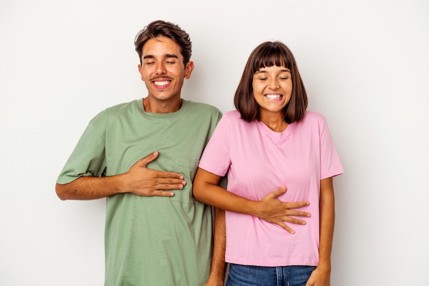 Jeune Couple Métis Isolé Sur Fond Blanc Touche Le Ventre, Sourit Doucement, Concept De Manger Et De Satisfaction.