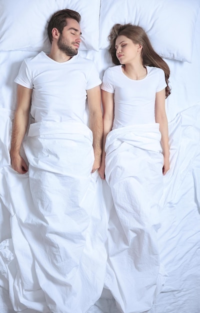 Jeune couple mignon ensemble au lit