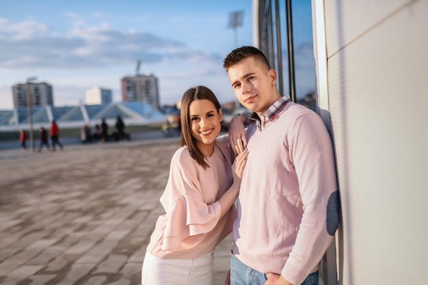 Jeune couple à la mode, debout à l'extérieur, posant