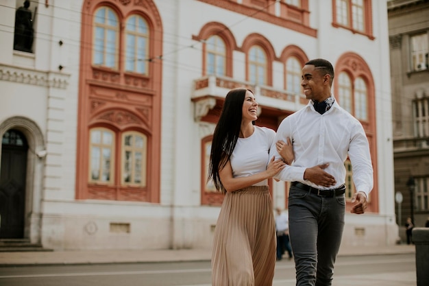 Jeune couple multiethnique marchant dans la rue