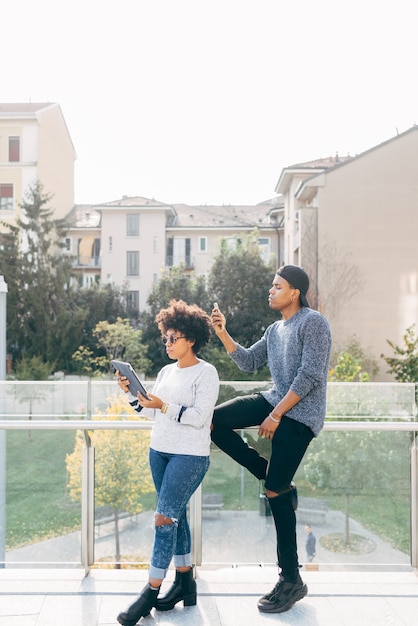 Jeune couple noir avec des appareils électroniques