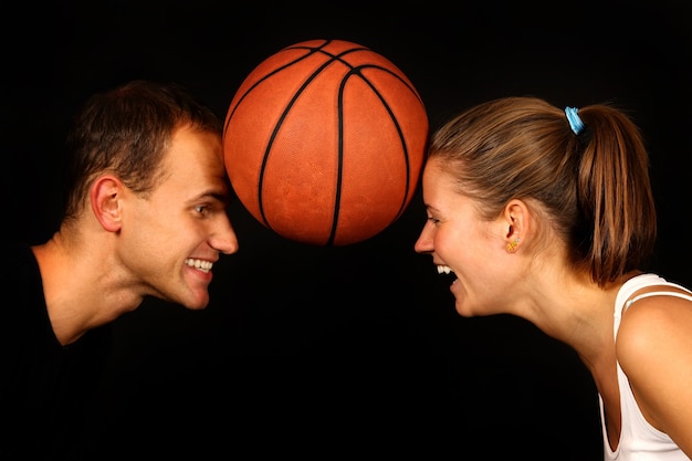 Jeune couple sur noir avec ballon de basket