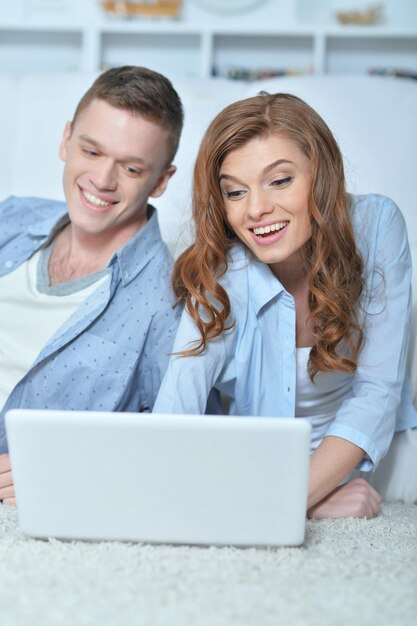 Un jeune couple avec un ordinateur portable à la maison