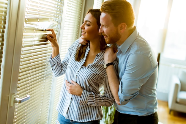 Jeune couple par la fenêtre