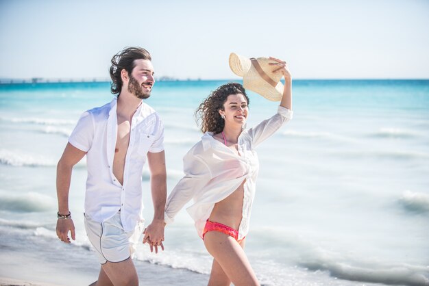 Jeune couple partage l'humeur heureuse et amoureuse sur la plage