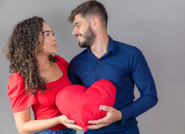 Jeune couple passionné tenant un coeur en peluche