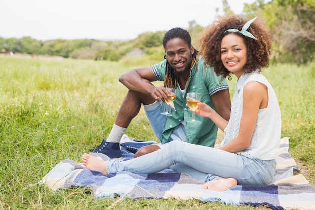 Jeune couple sur un pique-nique, boire du vin