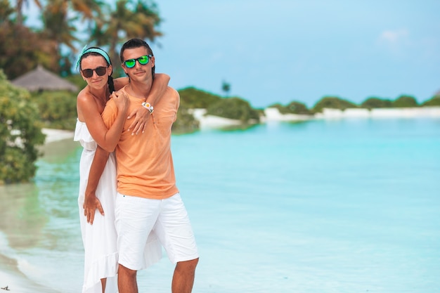 Jeune couple sur la plage blanche pendant les vacances d'été